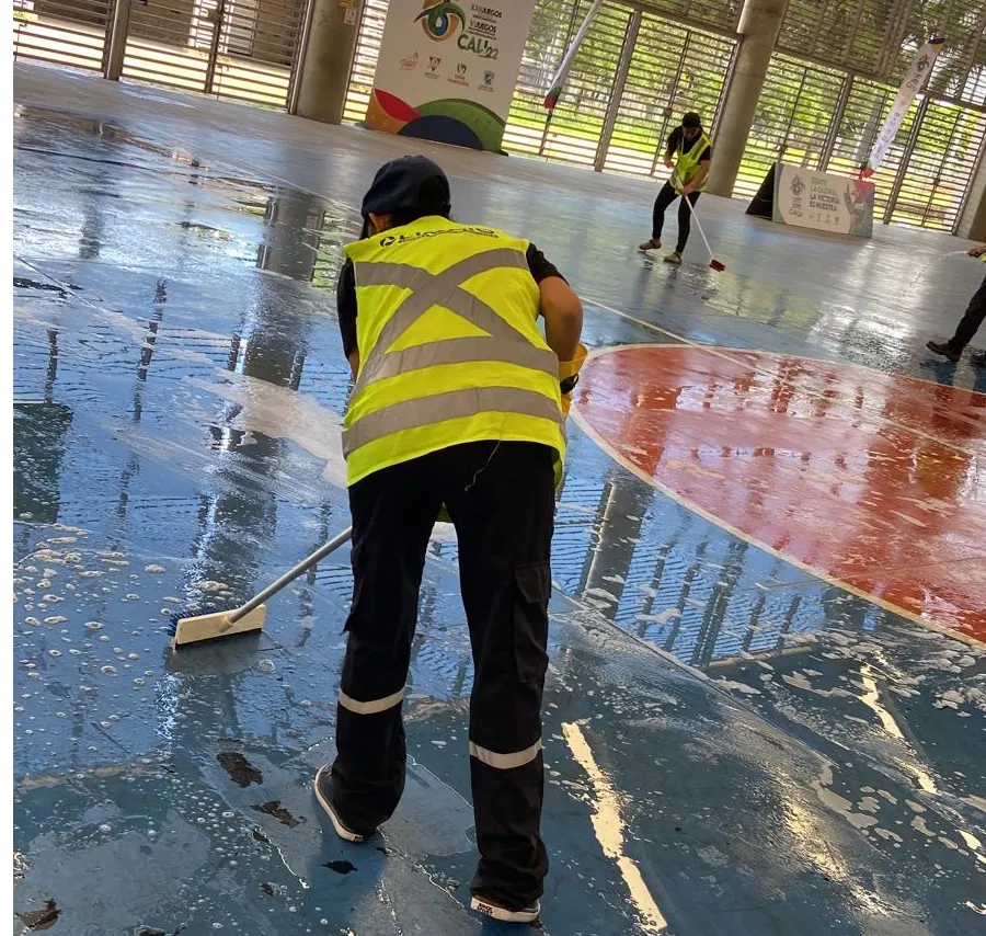 Operario de Limpio con hidrolavadora limpiando parqueadero